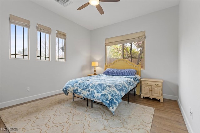 bedroom featuring visible vents, light wood-style flooring, baseboards, and ceiling fan