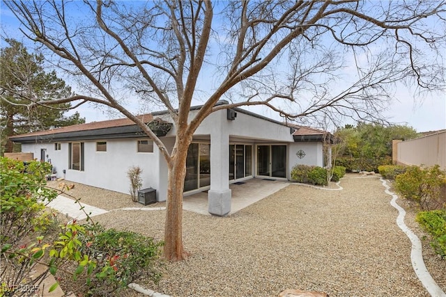 back of house with stucco siding, fence, and a patio area