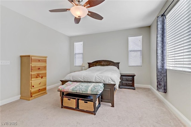 bedroom with a ceiling fan, baseboards, and light carpet