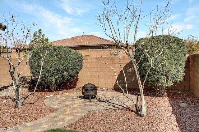 view of yard with an outdoor fire pit, a fenced backyard, and a patio area