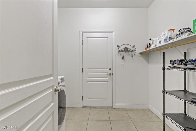 laundry room with laundry area, light tile patterned flooring, and baseboards