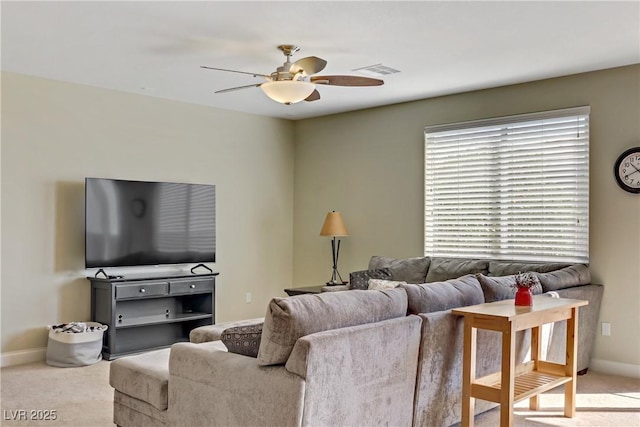 carpeted living area with visible vents, baseboards, and a ceiling fan