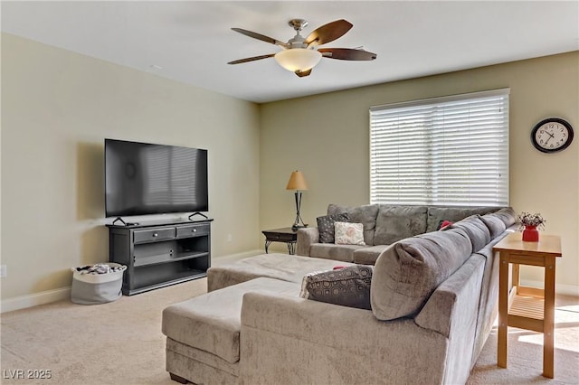 carpeted living area with baseboards and a ceiling fan