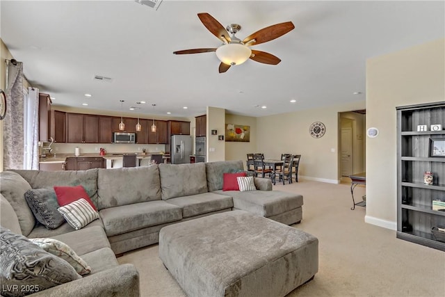 living area featuring a ceiling fan, recessed lighting, light colored carpet, and baseboards