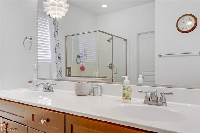 bathroom featuring a sink, recessed lighting, a stall shower, and double vanity