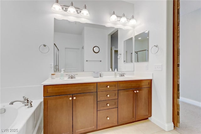 bathroom with a garden tub, double vanity, baseboards, and a sink