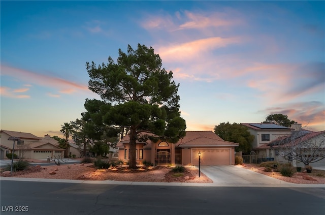 mediterranean / spanish-style home featuring concrete driveway, a tiled roof, and a garage