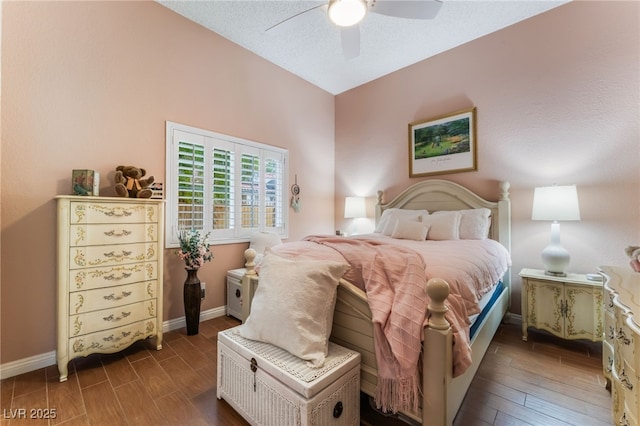 bedroom with a textured ceiling, a ceiling fan, baseboards, and wood tiled floor