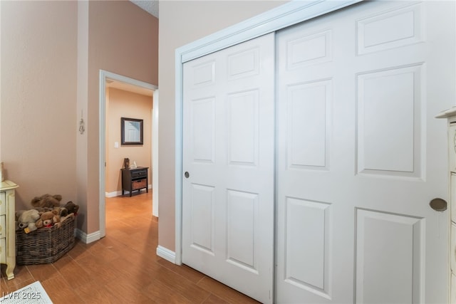 interior space with a closet, light wood-type flooring, and baseboards