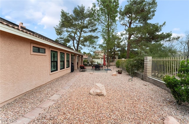 view of yard featuring a patio, an outdoor fire pit, and a fenced backyard