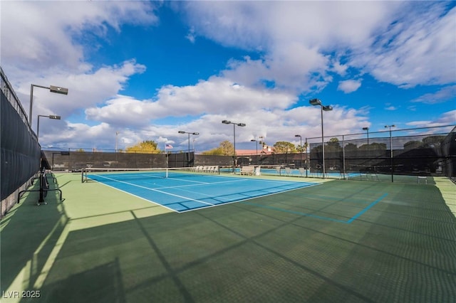 view of tennis court featuring fence