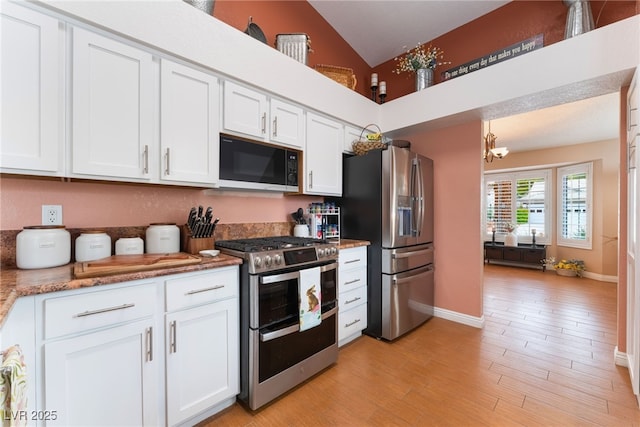 kitchen with light wood-type flooring, baseboards, appliances with stainless steel finishes, and white cabinetry