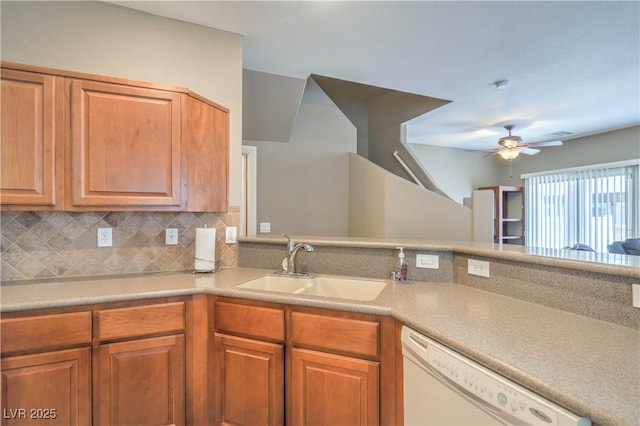 kitchen with a sink, tasteful backsplash, white dishwasher, and light countertops