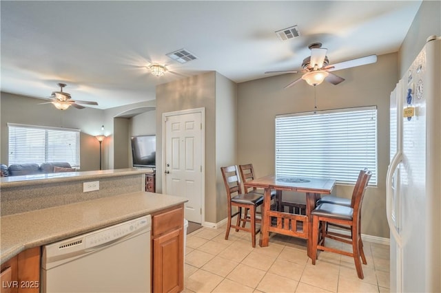 kitchen with a ceiling fan, white appliances, light countertops, and visible vents