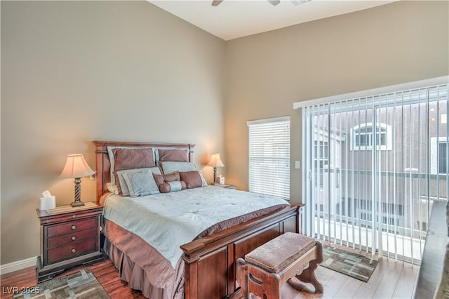 bedroom with dark wood finished floors, access to exterior, a ceiling fan, and baseboards