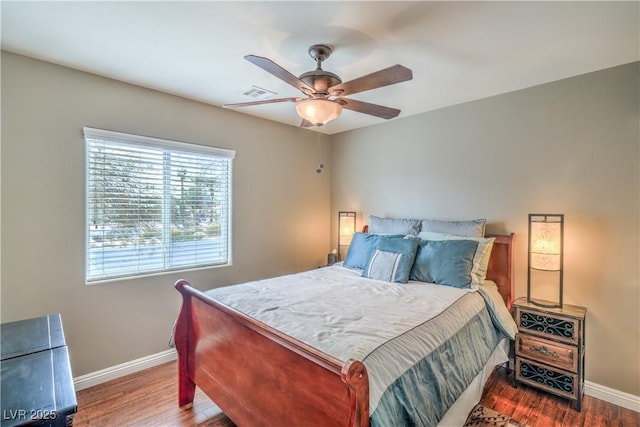 bedroom with ceiling fan, visible vents, baseboards, and wood finished floors