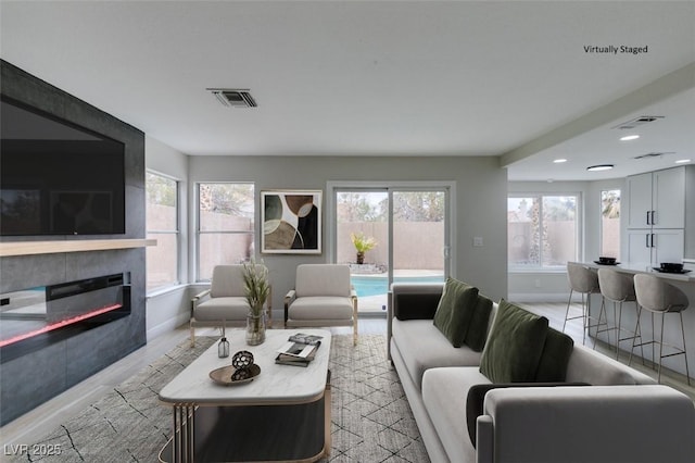 living room with visible vents, a large fireplace, and baseboards