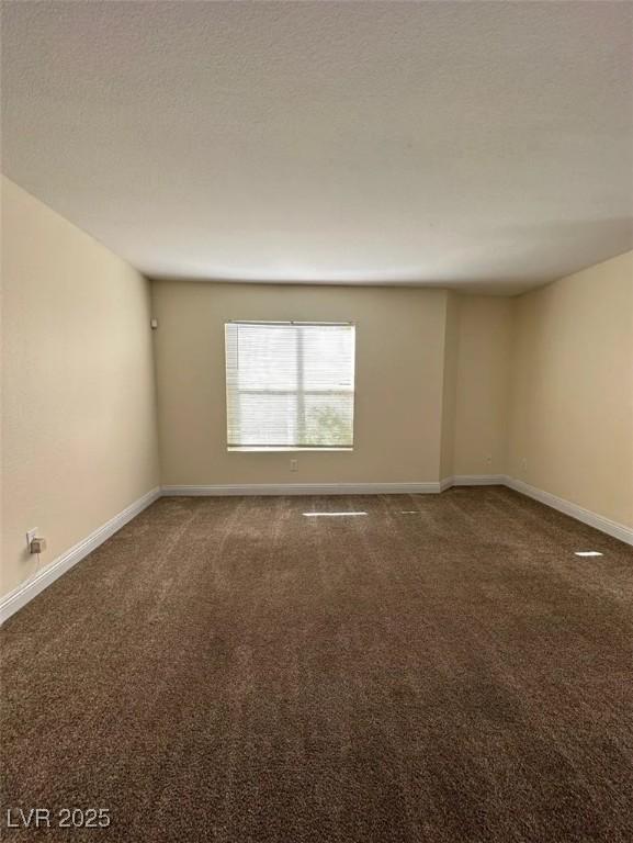 empty room featuring baseboards, a textured ceiling, and carpet flooring