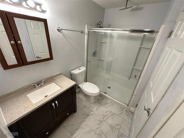 bathroom featuring a shower stall, toilet, a textured wall, marble finish floor, and vanity