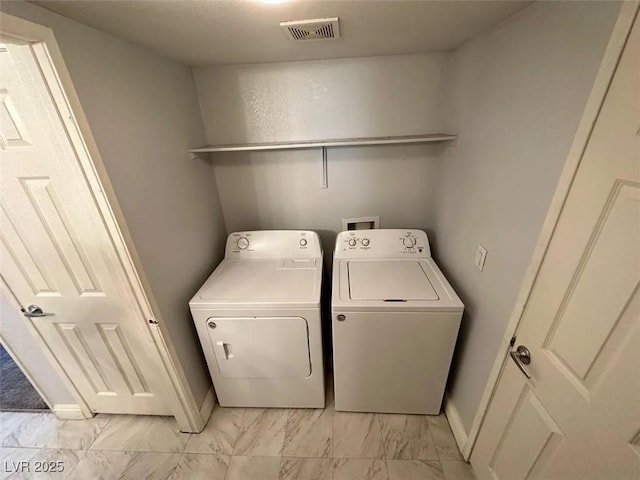 laundry area with visible vents, marble finish floor, washer and dryer, baseboards, and laundry area