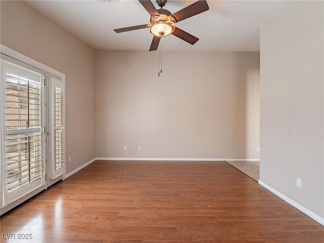 spare room with baseboards, a ceiling fan, and wood finished floors