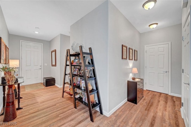 corridor featuring light wood-type flooring and baseboards