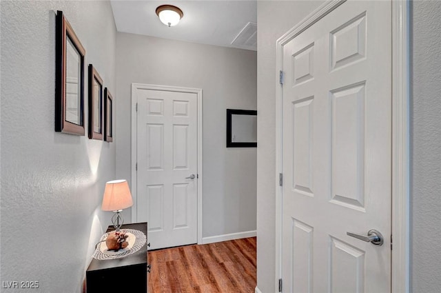 hall with light wood-type flooring and baseboards