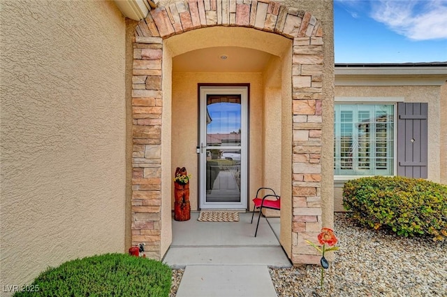 entrance to property with stone siding and stucco siding