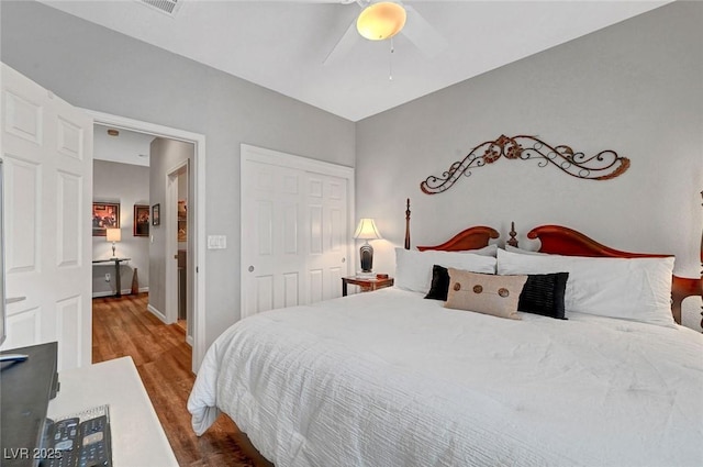 bedroom featuring ceiling fan, a closet, baseboards, and wood finished floors