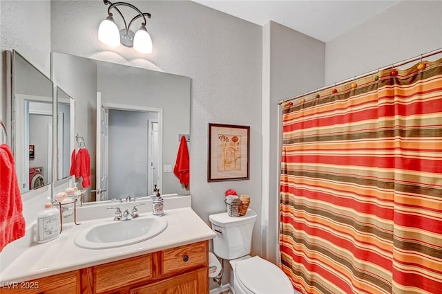 bathroom featuring vanity, a shower with shower curtain, toilet, and a textured wall