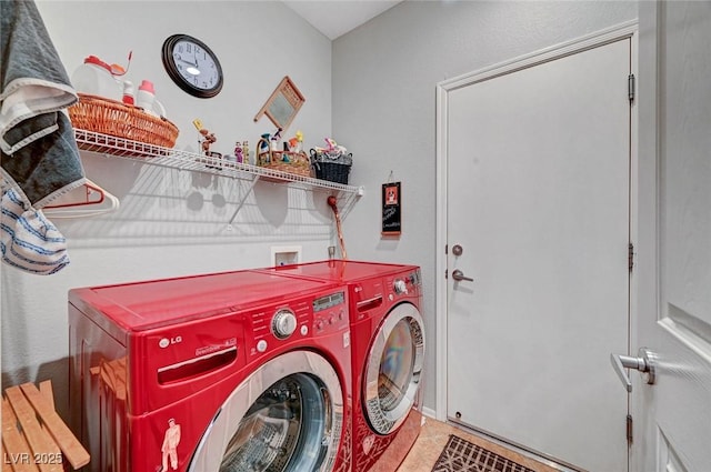 washroom featuring tile patterned flooring, laundry area, and washing machine and clothes dryer