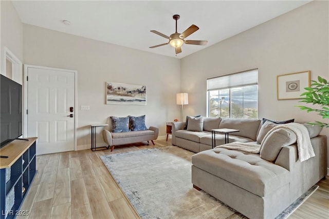 living room featuring a ceiling fan, light wood-type flooring, and baseboards