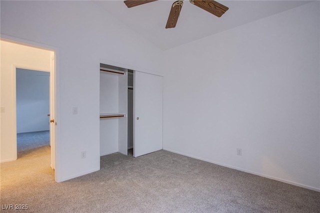 unfurnished bedroom with a ceiling fan, baseboards, carpet floors, vaulted ceiling, and a closet