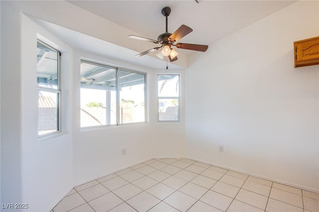 empty room featuring baseboards, light tile patterned flooring, and a ceiling fan