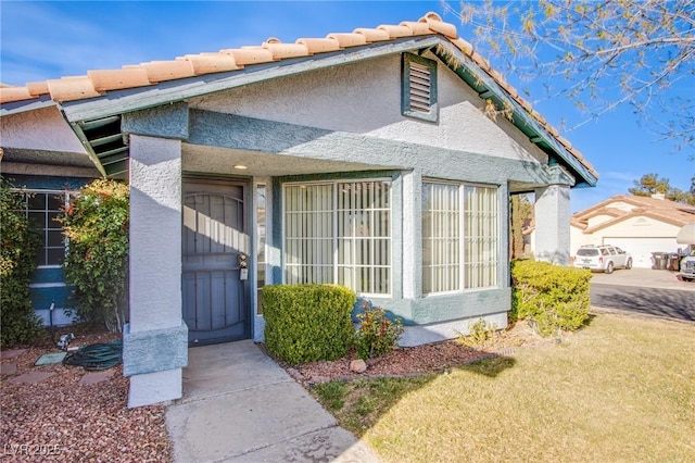 property entrance featuring stucco siding and a tile roof