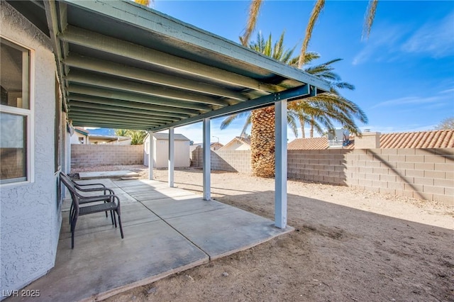 view of patio / terrace featuring a shed, an outdoor structure, and a fenced backyard