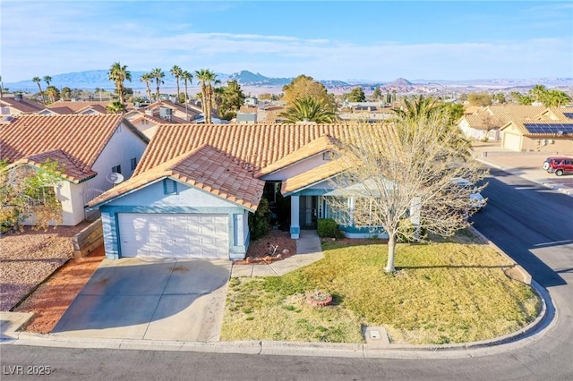 view of front of home featuring a mountain view, a garage, driveway, and a tiled roof