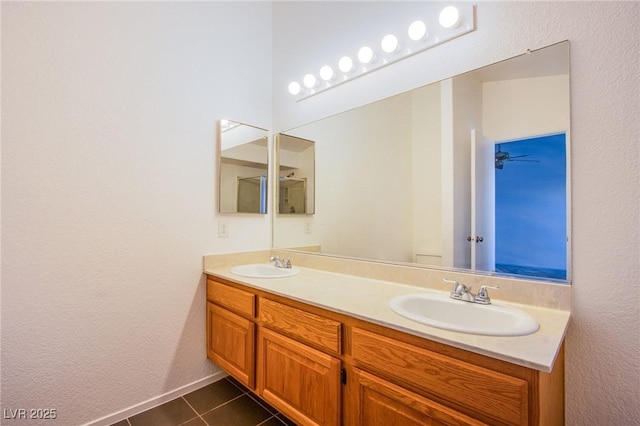 full bath with a sink, double vanity, and tile patterned flooring