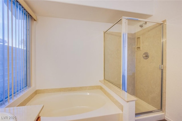 bathroom featuring vanity, a bath, and a shower stall