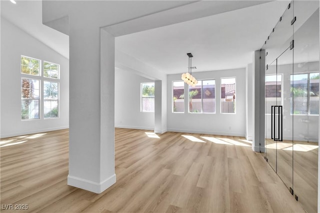 unfurnished dining area featuring baseboards, plenty of natural light, and light wood finished floors