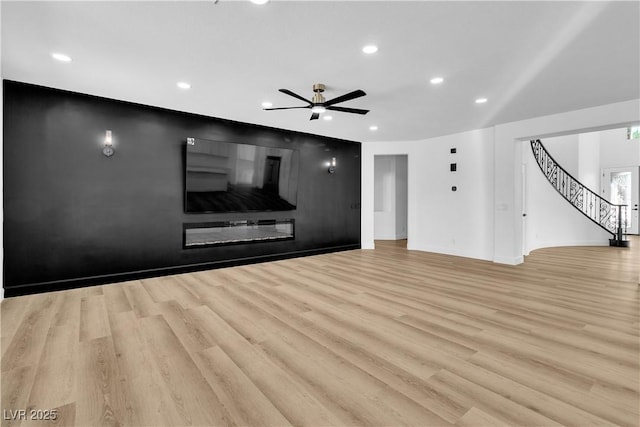 unfurnished living room with baseboards, light wood finished floors, recessed lighting, ceiling fan, and stairs