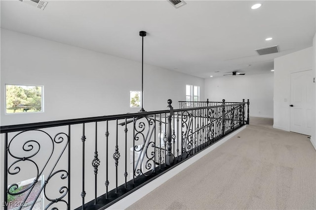 hallway featuring visible vents, baseboards, recessed lighting, carpet flooring, and an upstairs landing