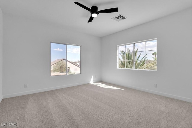 empty room with visible vents, baseboards, carpet, and a ceiling fan