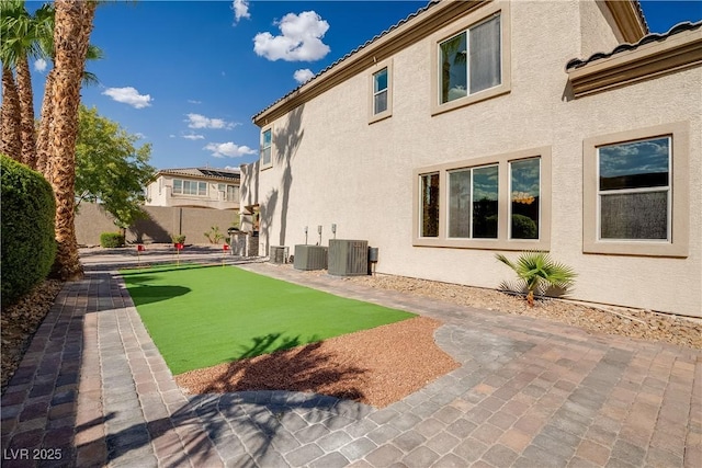 view of yard with a patio, central AC, and fence