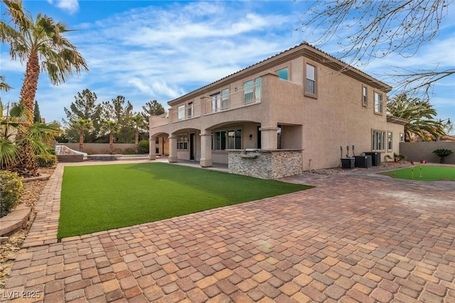 rear view of property featuring a patio area, central air condition unit, stucco siding, and fence