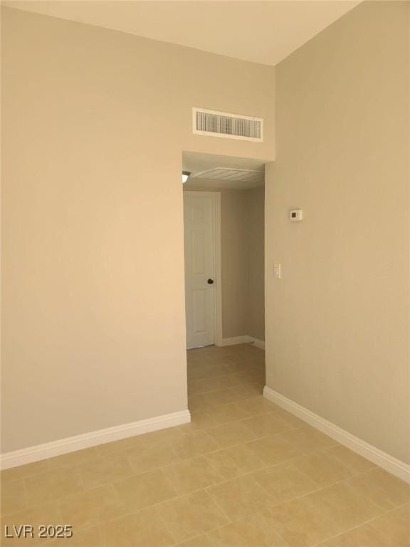 empty room featuring baseboards and visible vents