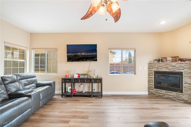 living room with ceiling fan, baseboards, recessed lighting, wood finished floors, and a glass covered fireplace