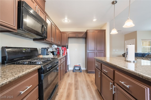 kitchen with light wood-type flooring, black appliances, decorative light fixtures, recessed lighting, and light stone countertops