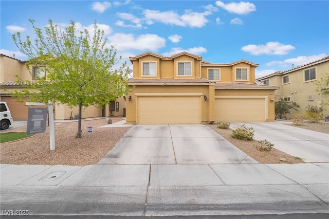 view of front of property featuring stucco siding, a tiled roof, concrete driveway, and a garage