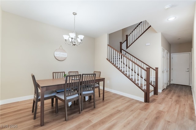 dining room with stairway, baseboards, light wood finished floors, and a chandelier